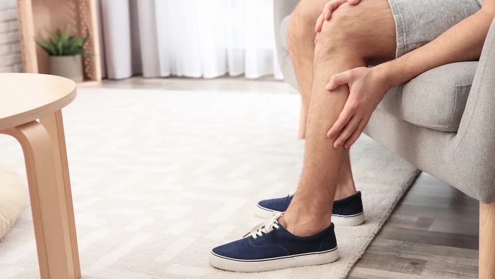 Person resting heavy, tired legs at the end of the day