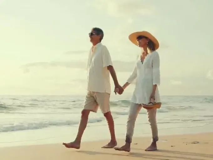 A couple walking on the beach — active again after vein treatment